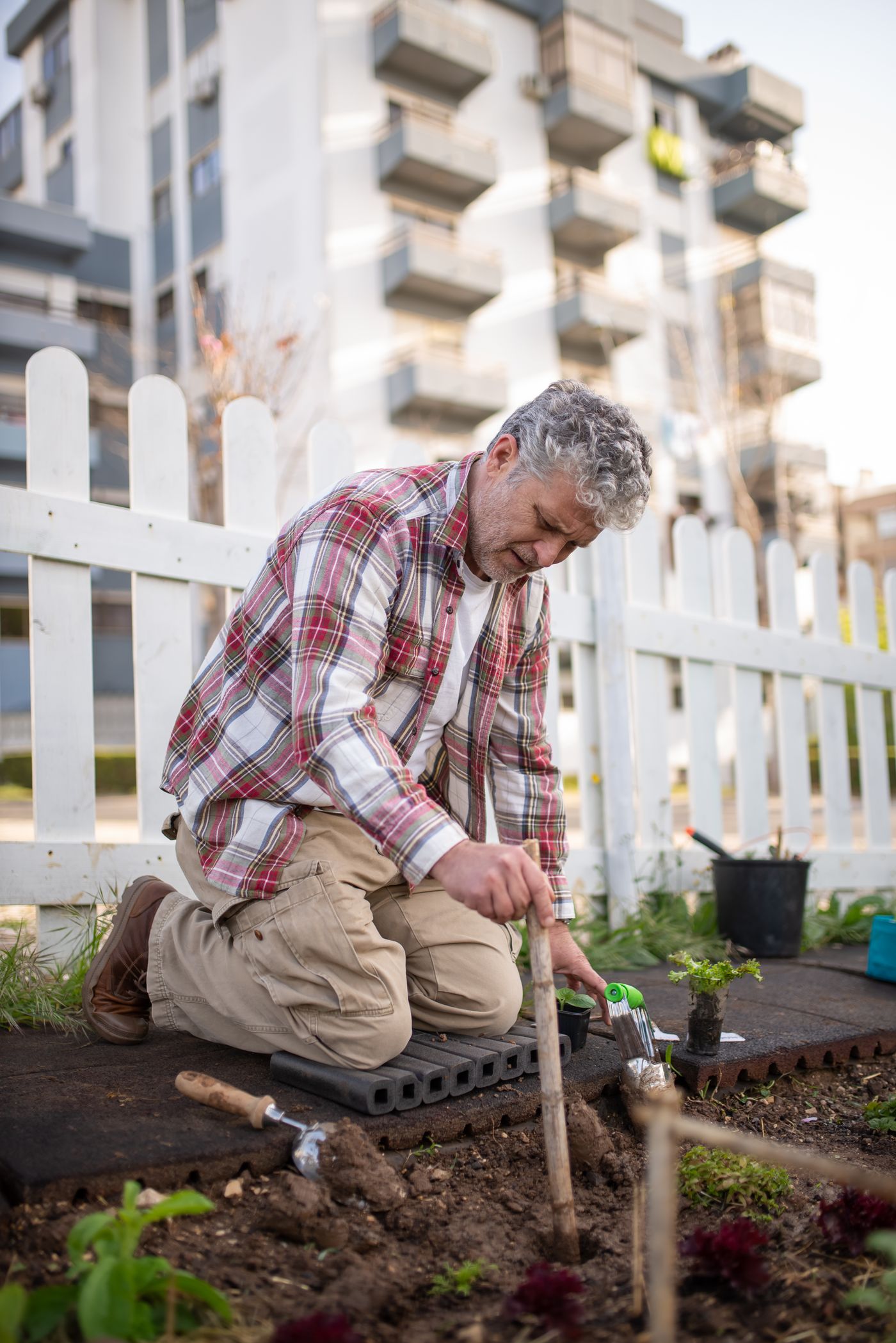 Un monsieur âgé jardine en extérieur